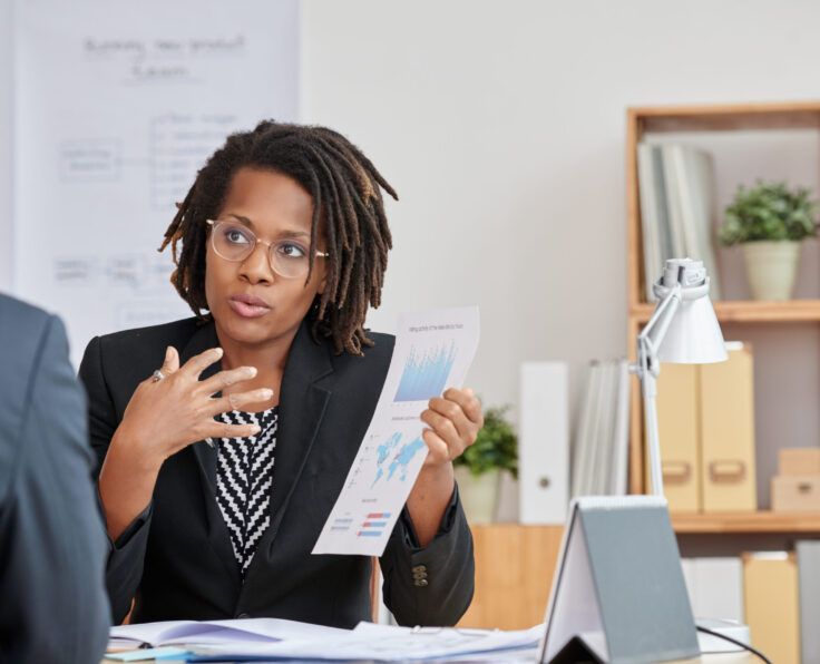 African-American business woman explaining results of her work to colleague